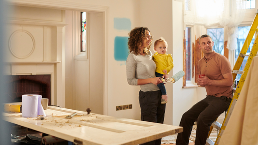 In a warmly lit workshop, a close-knit family of four is deeply engaged in a DIY project, radiating a sense of camaraderie and creativity.