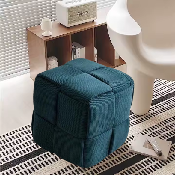 Dark teal corduroy ottoman with sturdy wood frame and unique textured design for home decor.