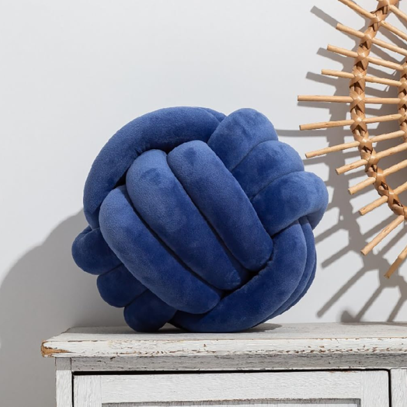 Close-up of blue accent pillow featuring a soft, raised geometric pattern. Stylish cushion for living room or bedroom.