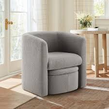 Velvet grey barrel accent chair with hidden ottoman, featuring flared arms, foam-filled seat and back, and matching toss pillows. Space-saving design with storable ottoman underneath. Sturdy solid wood frame with sled base for durability and stability. Ideal for adding style and comfort to any living space.
