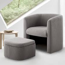 Velvet grey barrel accent chair with hidden ottoman, featuring flared arms, foam-filled seat and back, and matching toss pillows. Space-saving design with storable ottoman underneath. Sturdy solid wood frame with sled base for durability and stability. Ideal for adding style and comfort to any living space.
