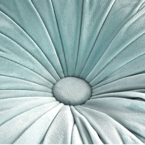 Aqua velvet round throw pillows with hand-sewn pleats and central button, set of two 14.5-inch decorative cushions styled on a modern sofa.