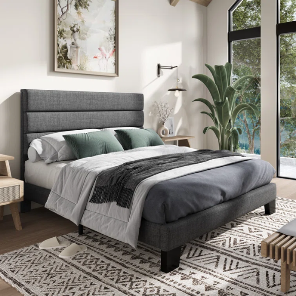 Dark grey upholstered queen platform bed with tufted headboard and wood slat support system