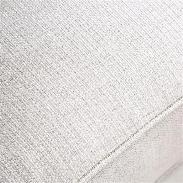 Beige tufted linen sofa with rolled arms, nailhead trim, tapered wooden legs, and accent pillows in transitional style.