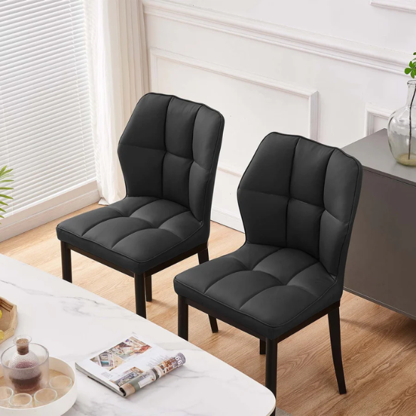 Set of two mid-century modern black faux leather dining chairs with checkered stitching and metal legs