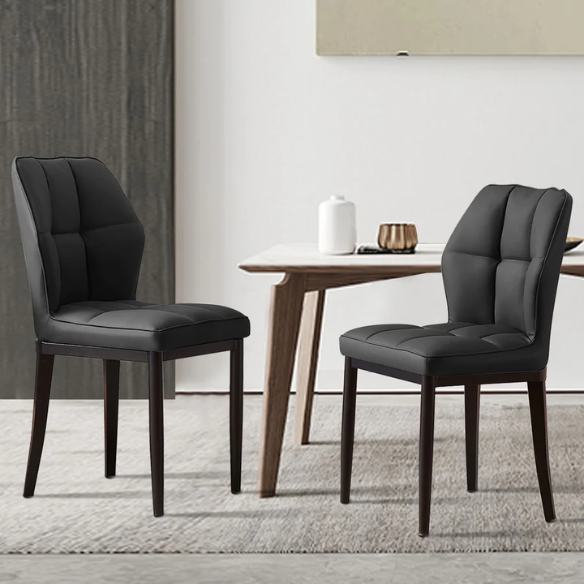 Set of two mid-century modern black faux leather dining chairs with checkered stitching and metal legs