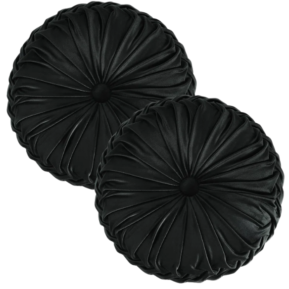 Black velvet round throw pillows with hand-sewn pleats and central button, set of two 14.5-inch plush decorative cushions styled on a modern neutral sofa.