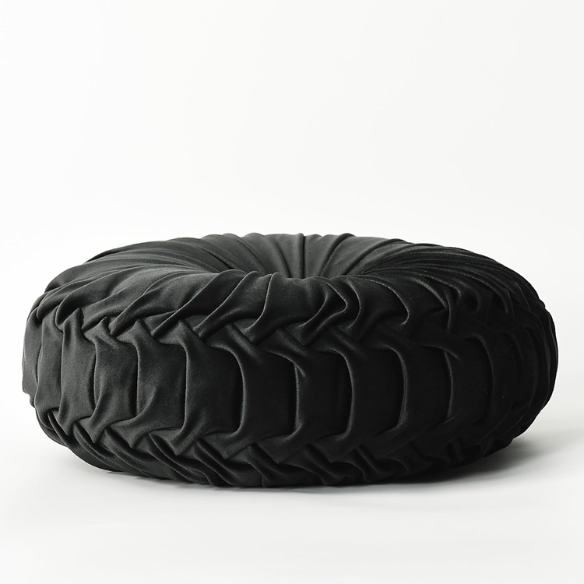 Black velvet round throw pillows with hand-sewn pleats and central button, set of two 14.5-inch plush decorative cushions styled on a modern neutral sofa.