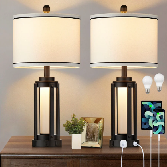 Set of two 25.3-inch modern black table lamps featuring white drum shades with black trim, built-in nightlight, USB and Type-C charging ports, and AC outlet on each base.