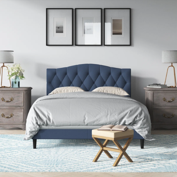 Blue upholstered king-size platform bed with tufted camelback headboard, solid wood frame, and slatted base with center support legs