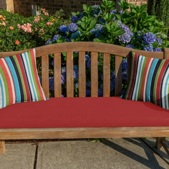 Striped accent pillow in blue, red, white, green, and black – reversible, weather-resistant, and overstuffed with plush polyester fill for indoor and outdoor use on patios, decks, or couches.