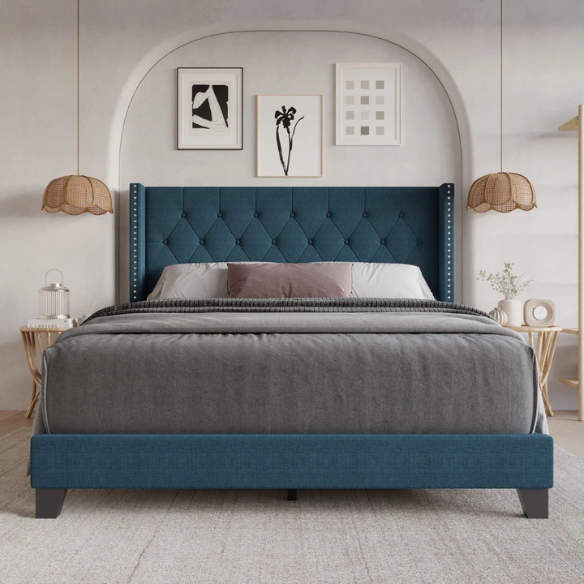 Blue upholstered full-size bed with tufted wingback headboard and nailhead trim