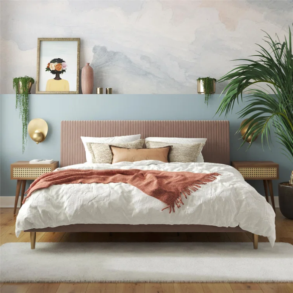 Blush pink velvet upholstered king-size platform bed with padded rectangular headboard, solid wood slats, and elegant low-profile frame.