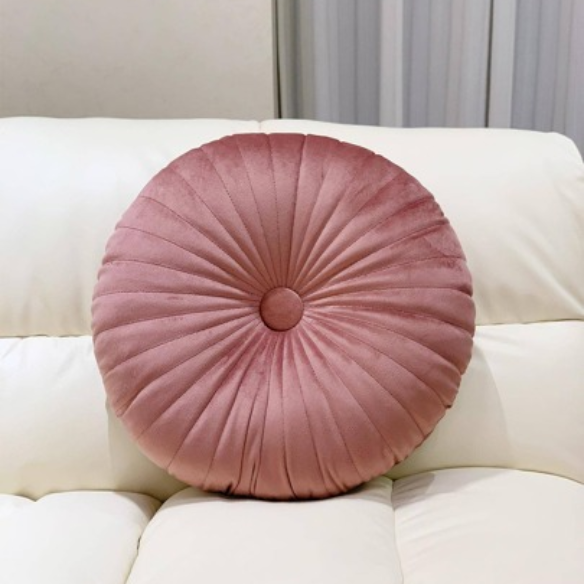 Blush velvet round throw pillow with button closure and pleated design, soft cotton fill for added comfort and support, perfect for home décor and sofa.