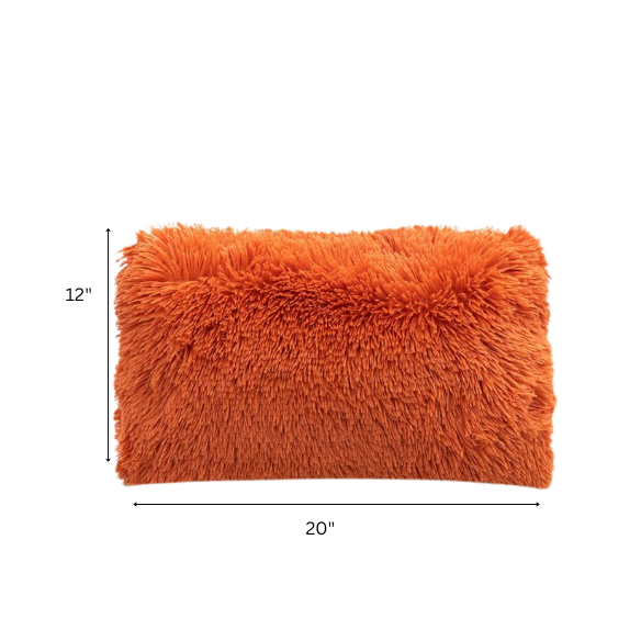 Set of two burnt orange faux fur throw pillows with shaggy texture on a modern sofa