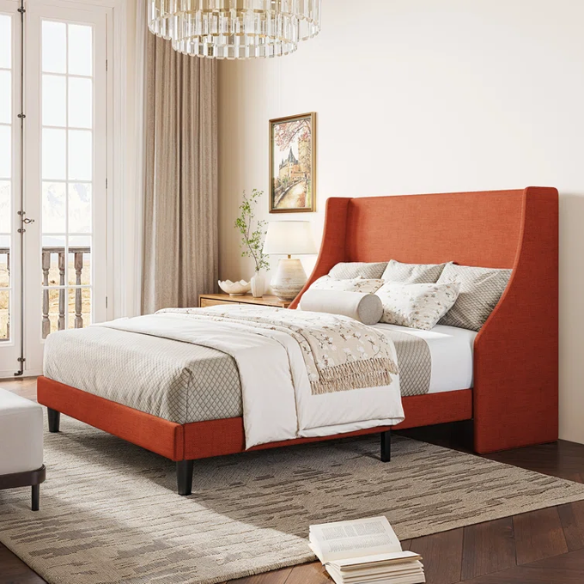 Burnt orange upholstered queen platform bed with wingback headboard, tapered legs, and slatted base – no box spring required