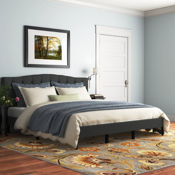 Charcoal grey upholstered king platform bed featuring a tufted camelback headboard, foam padding, and sturdy wood frame with slats and center support legs