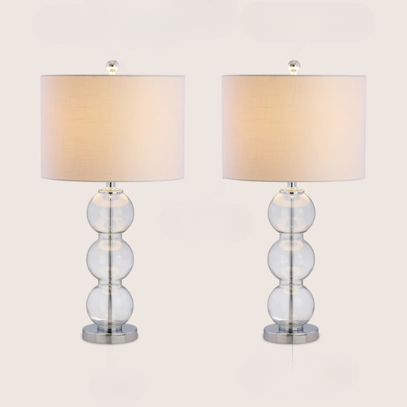 Set of 2 clear glass table lamps with triple-sphere design, polished silver accents, and white linen drum shades – elegant lighting for bedroom, living room, or office