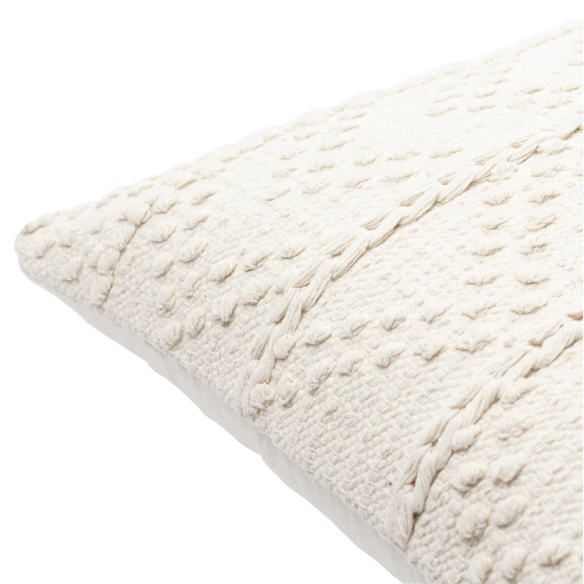 Cream handwoven boho throw pillow with chevron texture on a modern neutral-toned sofa