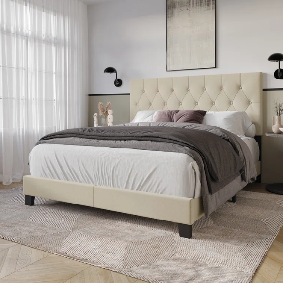 Cream linen full size upholstered bed with button tufted headboard and low-profile legs