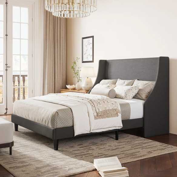 Dark grey upholstered queen platform bed with wingback headboard, slatted base, and black tapered legs – no box spring required