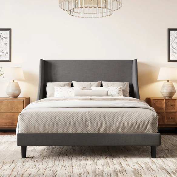 Dark grey upholstered queen platform bed with wingback headboard, slatted base, and black tapered legs – no box spring required