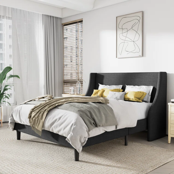 Dark grey upholstered queen platform bed with wingback headboard, slatted base, and black tapered legs – no box spring required