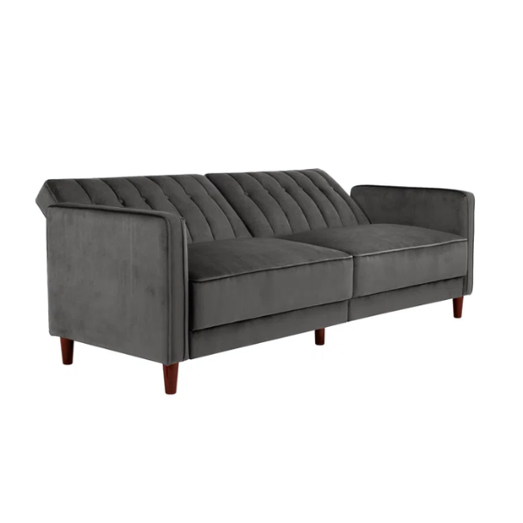 Dark grey velvet convertible sofa with vertical tufting, split-back design, square arms, and brown tapered legs, convertible into a twin-size sleeper.
