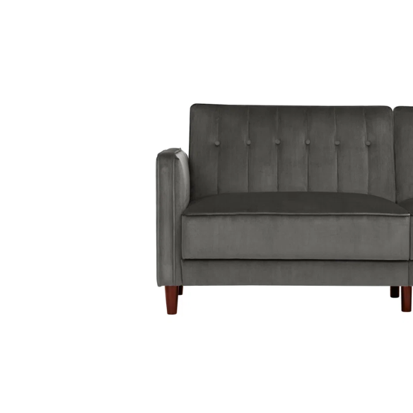 Dark grey velvet convertible sofa with vertical tufting, split-back design, square arms, and brown tapered legs, convertible into a twin-size sleeper.