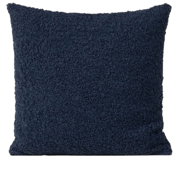 Deep navy blue bouclé throw pillow with looped texture, square accent pillow on a modern sofa