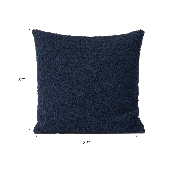 Deep navy blue bouclé throw pillow with looped texture, square accent pillow on a modern sofa