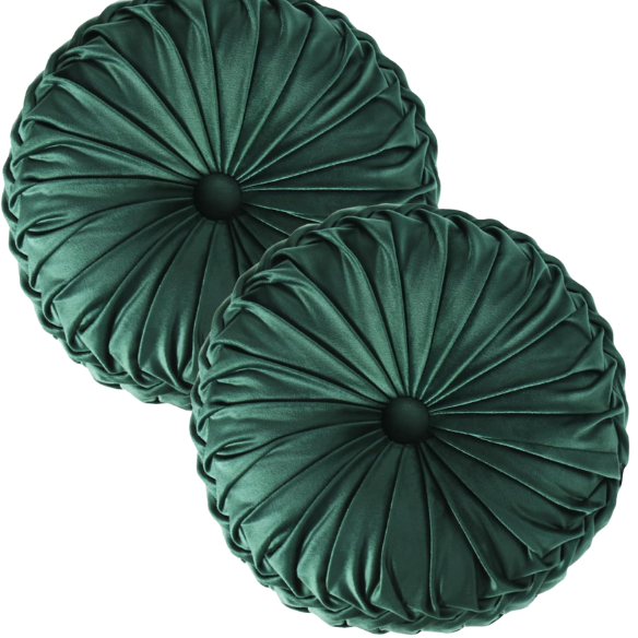 Emerald green velvet round throw pillows with hand-pleated detail and central button, 14.5-inch set of two on a white sofa in a stylish living room.