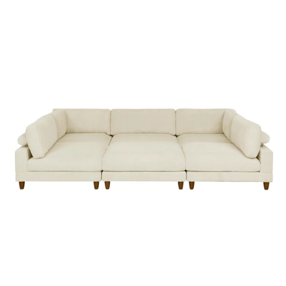 Beige modular sectional sofa with corduroy upholstery, removable cushions, and matching ottoman – seats six in a modern L-shaped or U-shaped layout with solid wood legs.