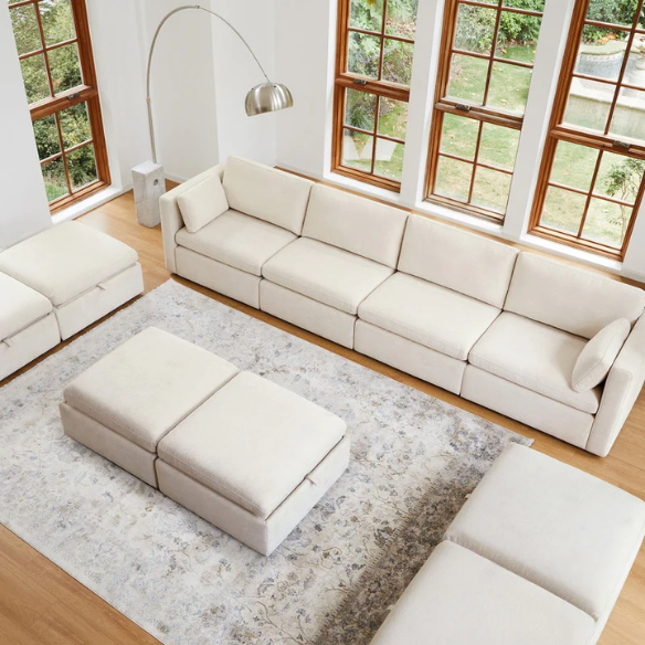 Beige six-piece modular sofa set featuring wide chenille-upholstered seats, two storage ottomans with gas-lift lids, and reversible cushions — ideal for contemporary, mid-century, or transitional interiors.