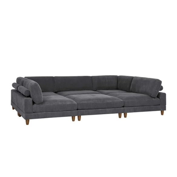 Dark grey modular sectional sofa with soft corduroy upholstery, matching ottoman, and removable cushions — seats six with flexible L- or U-shaped configurations.