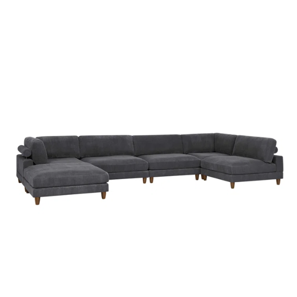 Dark grey modular sectional sofa with soft corduroy upholstery, matching ottoman, and removable cushions — seats six with flexible L- or U-shaped configurations.