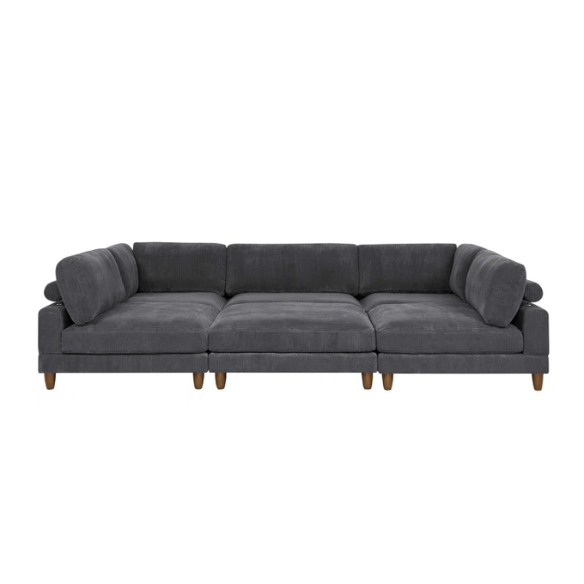 Dark grey modular sectional sofa with soft corduroy upholstery, matching ottoman, and removable cushions — seats six with flexible L- or U-shaped configurations.