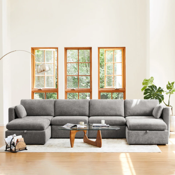 Grey six-piece modular sofa set with wide chenille-upholstered seats, two gas-lift storage ottomans, and plush reversible cushions — perfect for modern or transitional interiors.