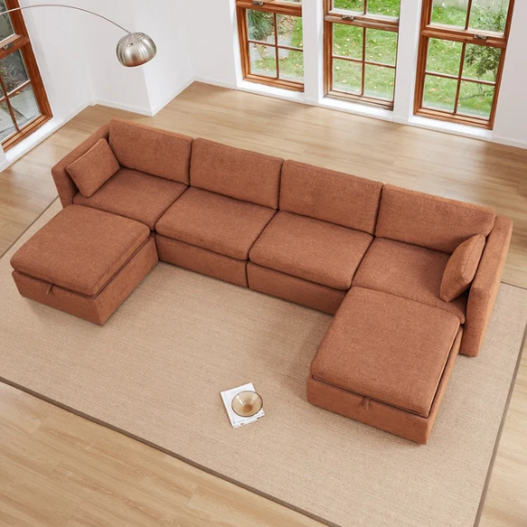 Terracotta six-piece modular sofa set featuring wide chenille-upholstered seats, two gas-lift storage ottomans, and reversible cushions — a bold, earthy centerpiece for modern or eclectic interiors.