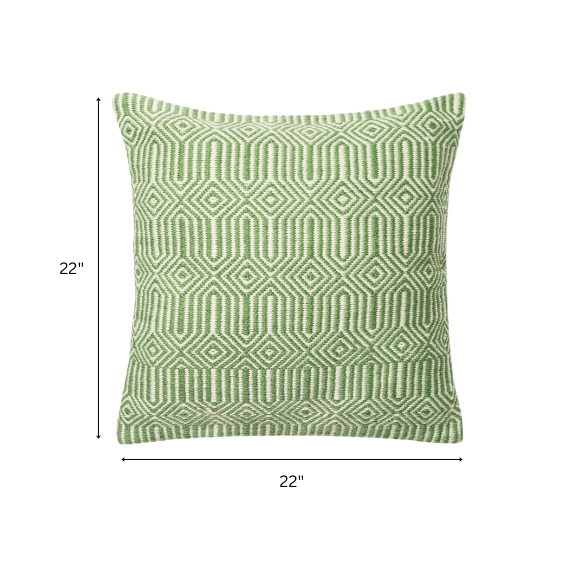 Green and cream geometric throw pillow on outdoor seating with modern patio decor