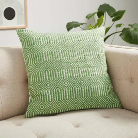 Green and cream geometric throw pillow on outdoor seating with modern patio decor