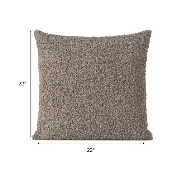 Grey bouclé throw pillow with soft looped texture, square accent pillow on a modern neutral-toned sofa