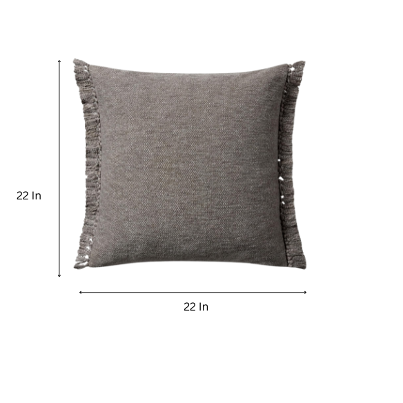 Grey cotton blend throw pillow with fringe, 22x22 square cushion featuring soft texture and hidden zipper, styled on a modern sofa for cozy, neutral decor.