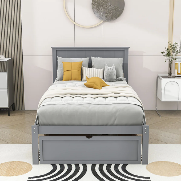 Grey twin platform bed made from solid pine wood with a rectangular headboard and a pull-out underbed storage drawer, featuring sturdy center support legs and a clean modern finish.