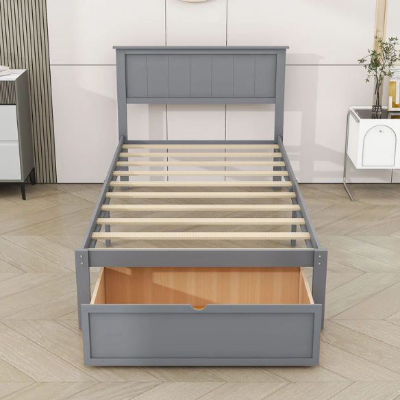 Grey twin platform bed made from solid pine wood with a rectangular headboard and a pull-out underbed storage drawer, featuring sturdy center support legs and a clean modern finish.