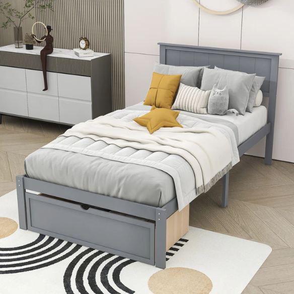 Grey twin platform bed made from solid pine wood with a rectangular headboard and a pull-out underbed storage drawer, featuring sturdy center support legs and a clean modern finish.