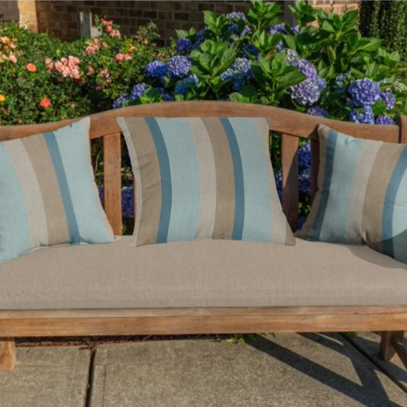 Striped accent pillow in light blue, misty teal, warm sand, and light beige – reversible and weather-resistant with plush polyester fill, perfect for indoor or outdoor spaces.