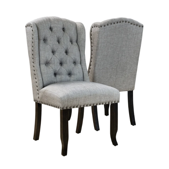 Set of two light grey farmhouse-style wingback dining chairs with button tufting, nailhead trim, and antique black tapered legs