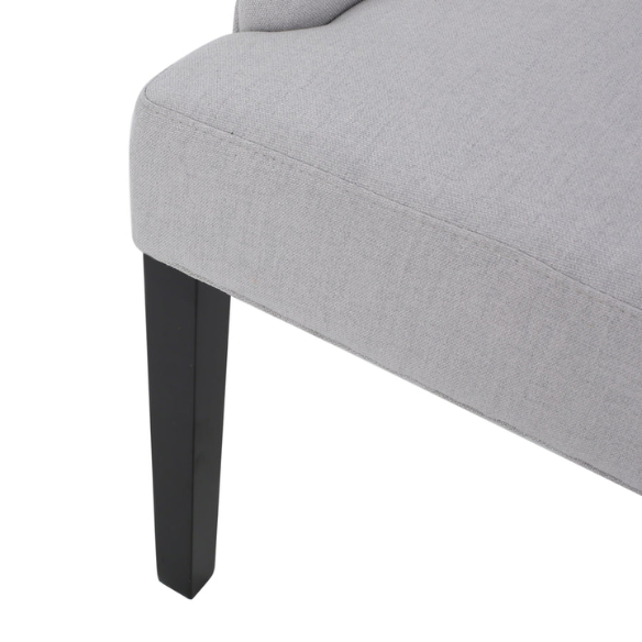 Set of four light grey upholstered dining chairs with diamond tufted backs, armless design, sloped armrests, and espresso brown wood legs.