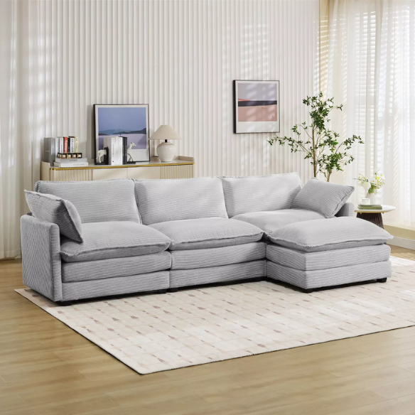Light grey modular three-seater corduroy sectional sofa with movable ottoman, modern L-shaped couch for living room with soft cushions and sturdy wood-metal frame.